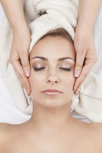 Young beautiful woman receiving face massage in spa salon